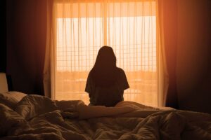 a young woman struggles in a dim room with the side effects of mdma ecstasy abuse