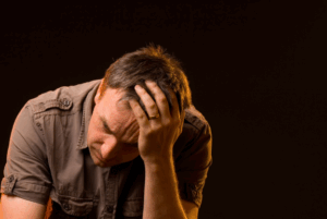a man sits with his head in his hand